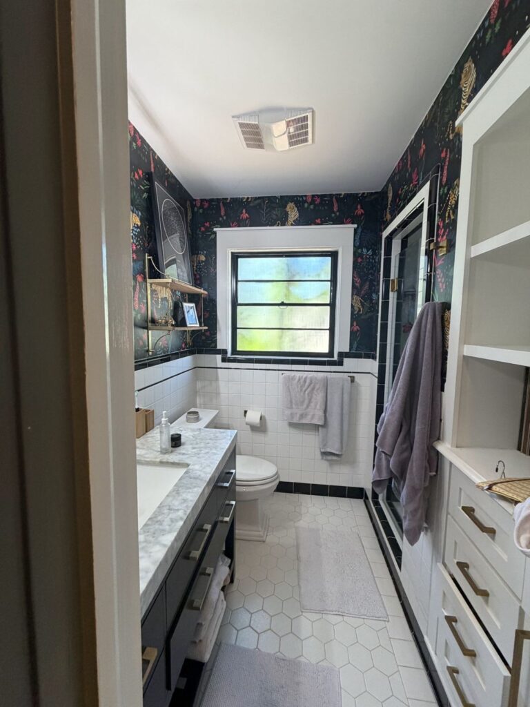 Before: narrow bathroom with vanity on one side and built-in cabinets on the other