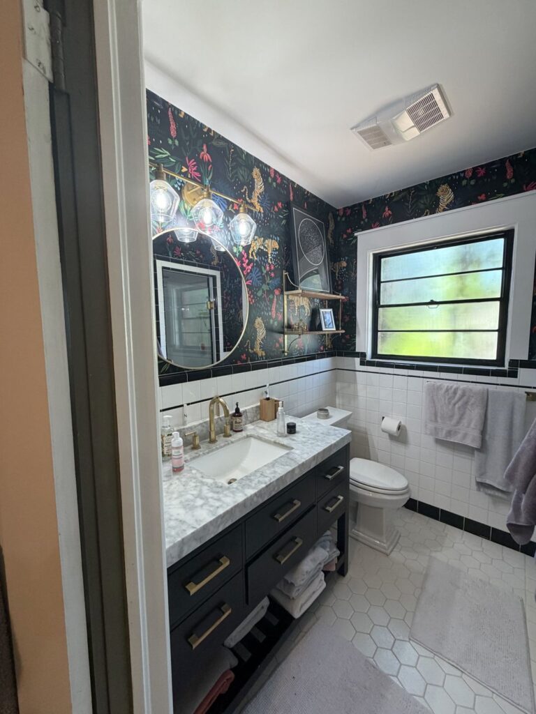 Before: single-sink navy vanity with marble top and tiger wallpaper